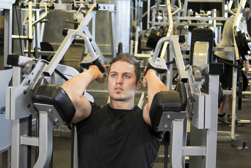 Demonstration of Machine Triceps Extension exercise showing proper form and technique