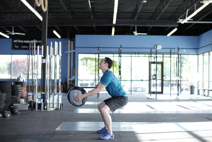 Demonstration of Medicine Ball Scoop Throw exercise showing proper form and technique