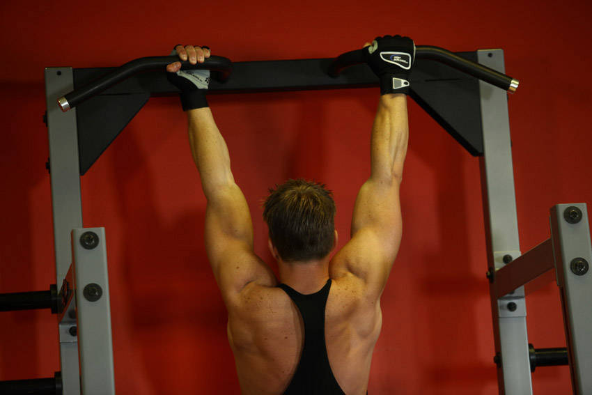 Demonstration of Mixed Grip Chin exercise showing proper form and technique