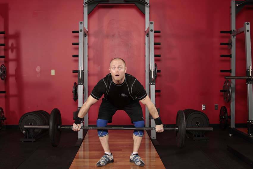 Demonstration of Muscle Snatch exercise showing proper form and technique