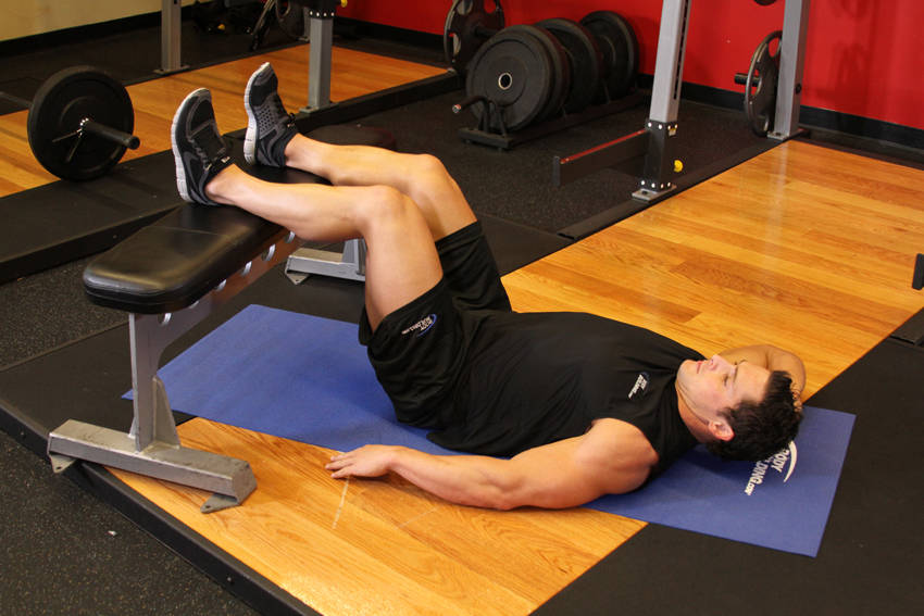 Demonstration of Oblique Crunches exercise showing proper form and technique