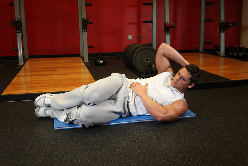 Demonstration of Oblique Crunches - On The Floor exercise showing proper form and technique