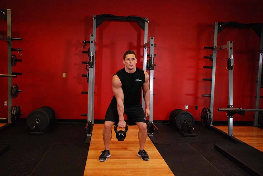 Demonstration of One-Arm Kettlebell Clean and Jerk exercise showing proper form and technique