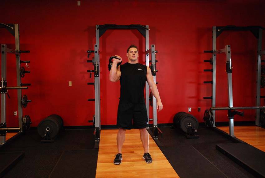 Demonstration of One-Arm Kettlebell Jerk exercise showing proper form and technique