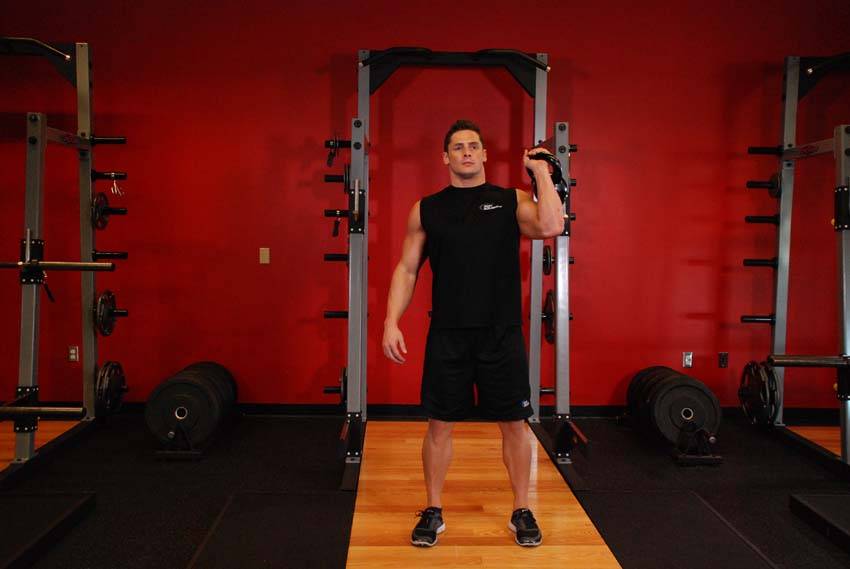 Demonstration of One-Arm Kettlebell Push Press exercise showing proper form and technique