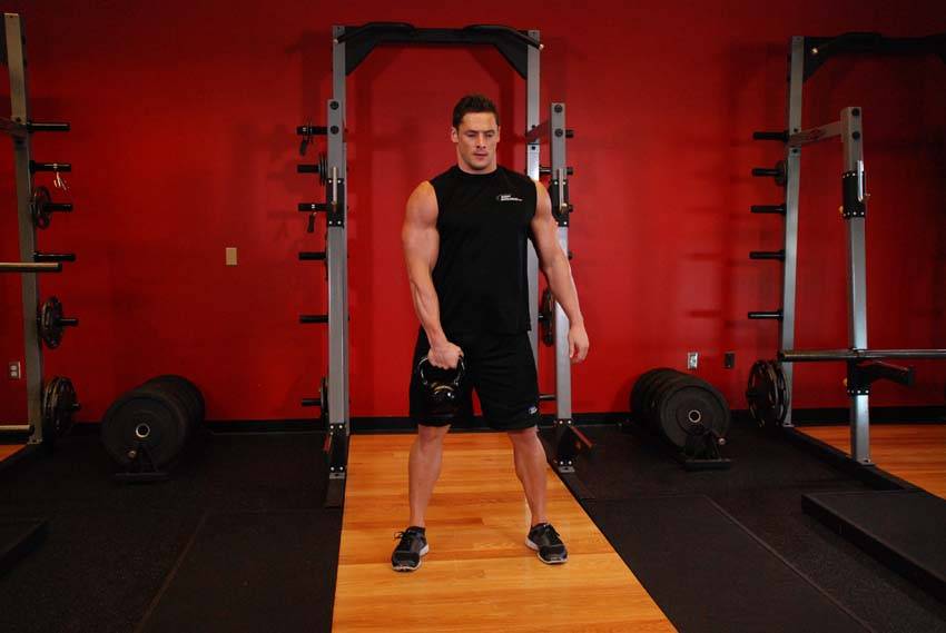Demonstration of One-Arm Kettlebell Snatch exercise showing proper form and technique