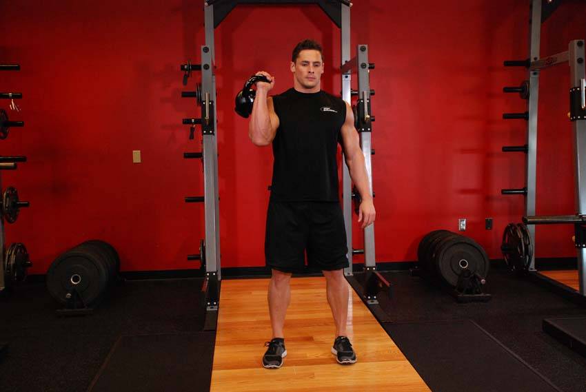 Demonstration of One-Arm Kettlebell Split Jerk exercise showing proper form and technique