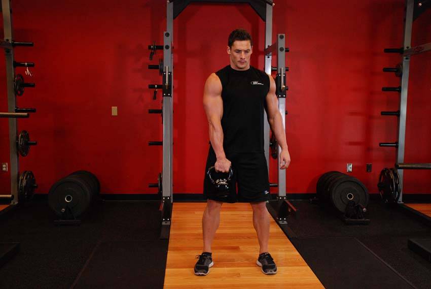 Demonstration of One-Arm Kettlebell Split Snatch exercise showing proper form and technique