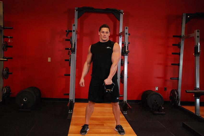 Demonstration of One-Arm Kettlebell Swings exercise showing proper form and technique