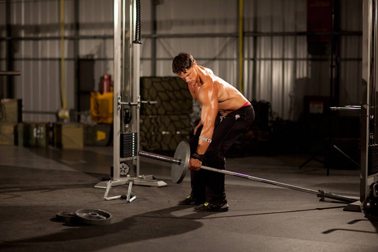 Demonstration of One-Arm Long Bar Row exercise showing proper form and technique