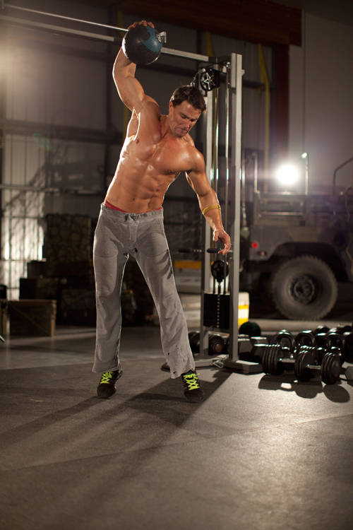 Demonstration of One-Arm Medicine Ball Slam exercise showing proper form and technique