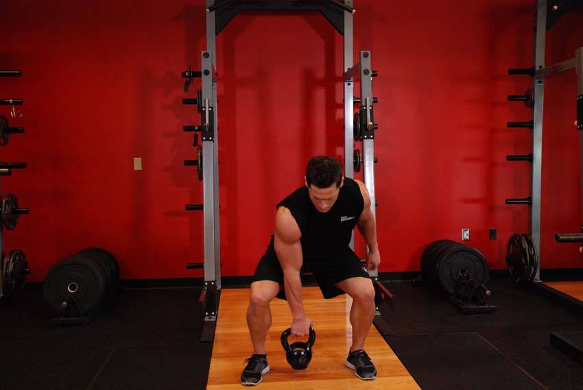 Demonstration of One-Arm Open Palm Kettlebell Clean exercise showing proper form and technique