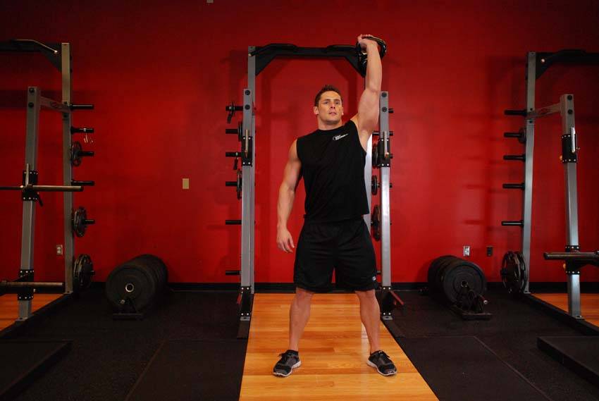 Demonstration of One-Arm Overhead Kettlebell Squats exercise showing proper form and technique