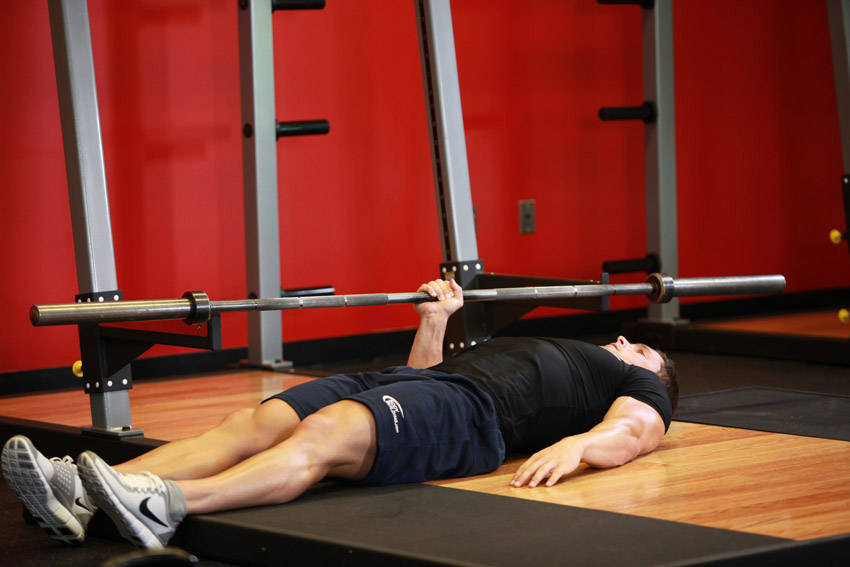 Demonstration of One Arm Floor Press exercise showing proper form and technique