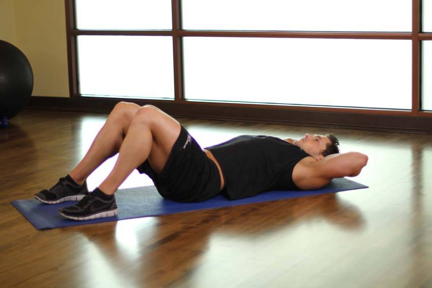 Demonstration of One Knee To Chest exercise showing proper form and technique