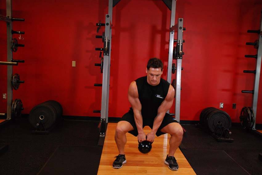 Demonstration of Open Palm Kettlebell Clean exercise showing proper form and technique