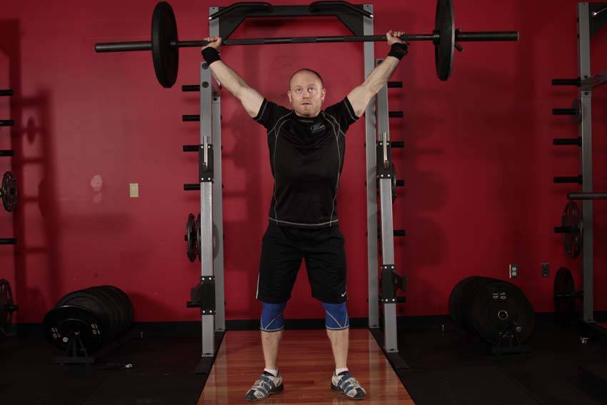 Demonstration of Overhead Squat exercise showing proper form and technique
