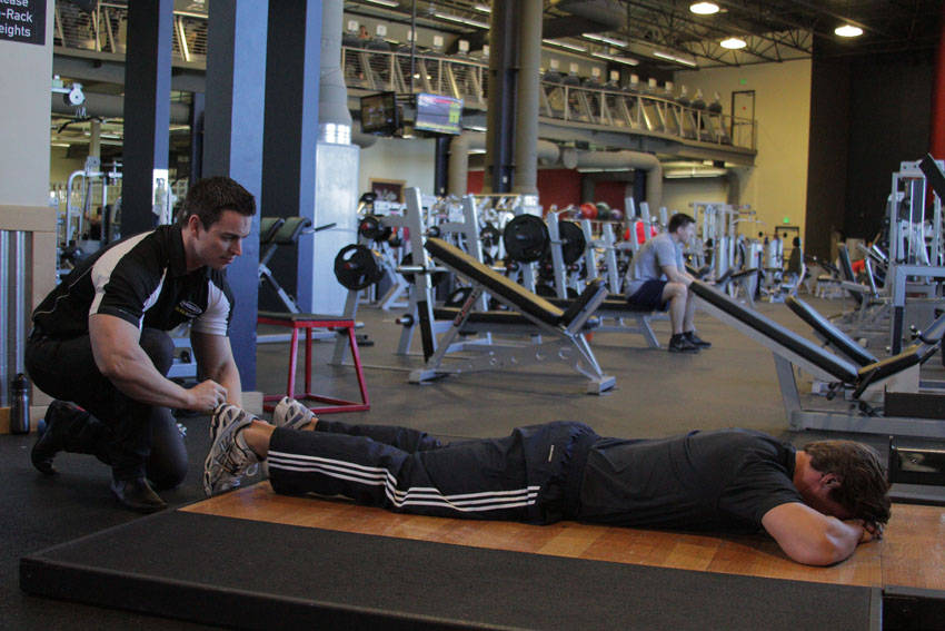 Demonstration of Prone Manual Hamstring exercise showing proper form and technique