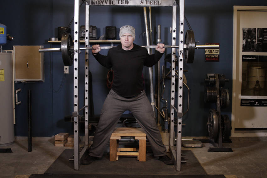 Demonstration of Reverse Band Box Squat exercise showing proper form and technique