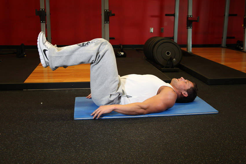 Demonstration of Reverse Crunch exercise showing proper form and technique