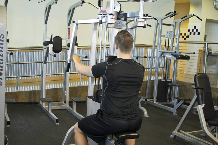Demonstration of Reverse Machine Flyes exercise showing proper form and technique