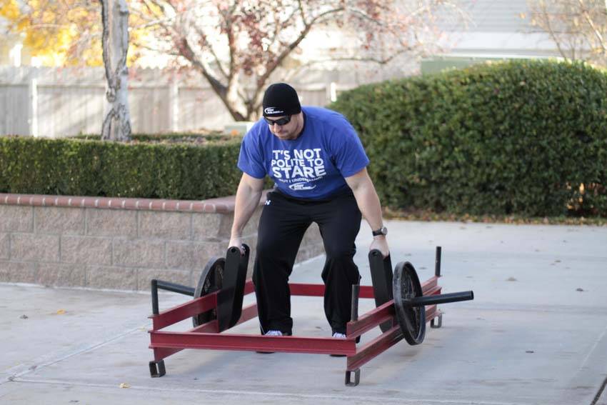Demonstration of Rickshaw Carry exercise showing proper form and technique