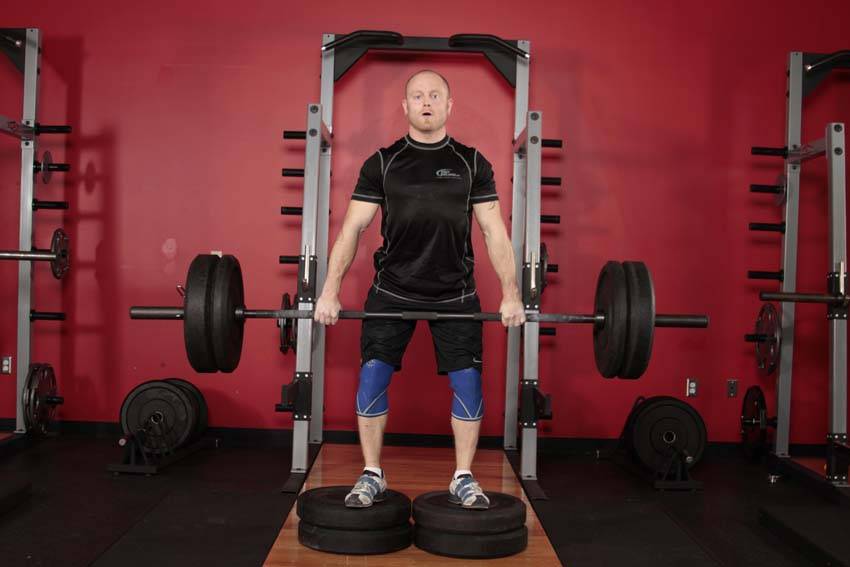Demonstration of Romanian Deadlift from Deficit exercise showing proper form and technique