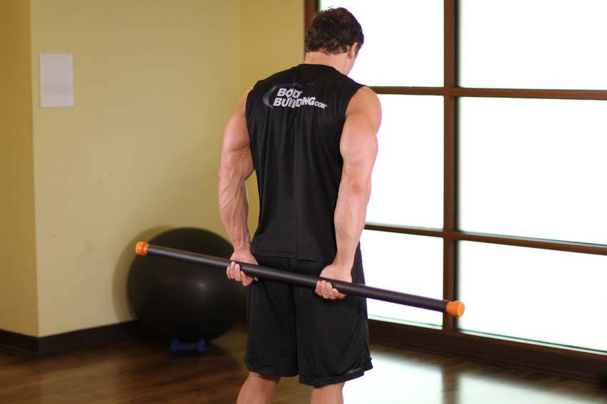 Demonstration of Round The World Shoulder Stretch exercise showing proper form and technique