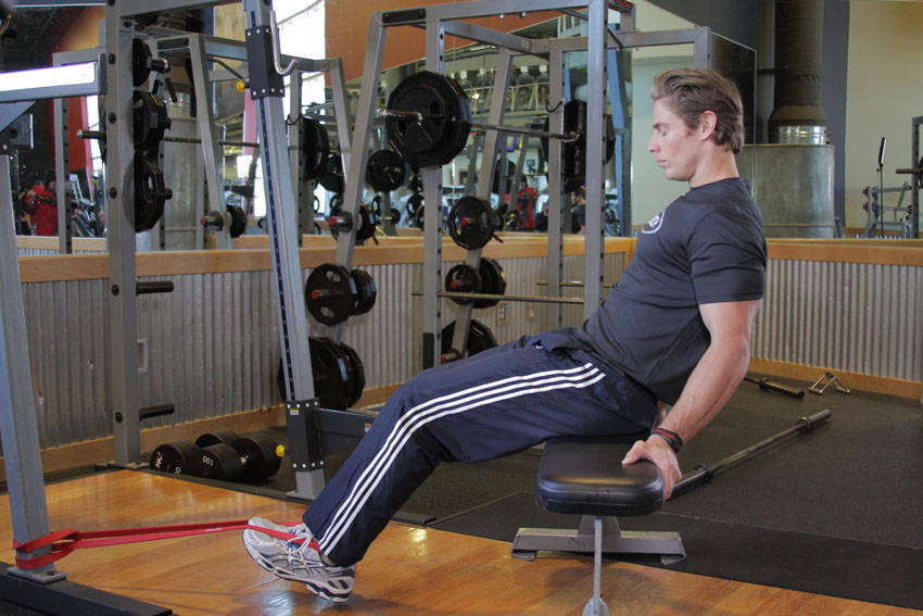 Demonstration of Seated Band Hamstring Curl exercise showing proper form and technique