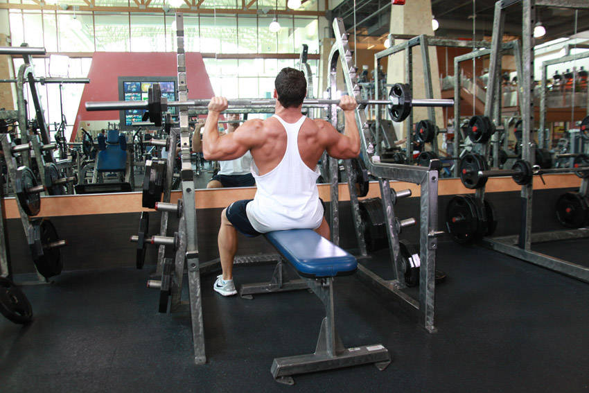 Demonstration of Seated Barbell Military Press exercise showing proper form and technique