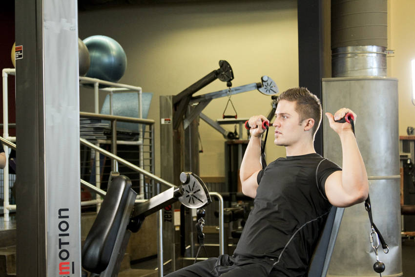 Demonstration of Seated Cable Shoulder Press exercise showing proper form and technique