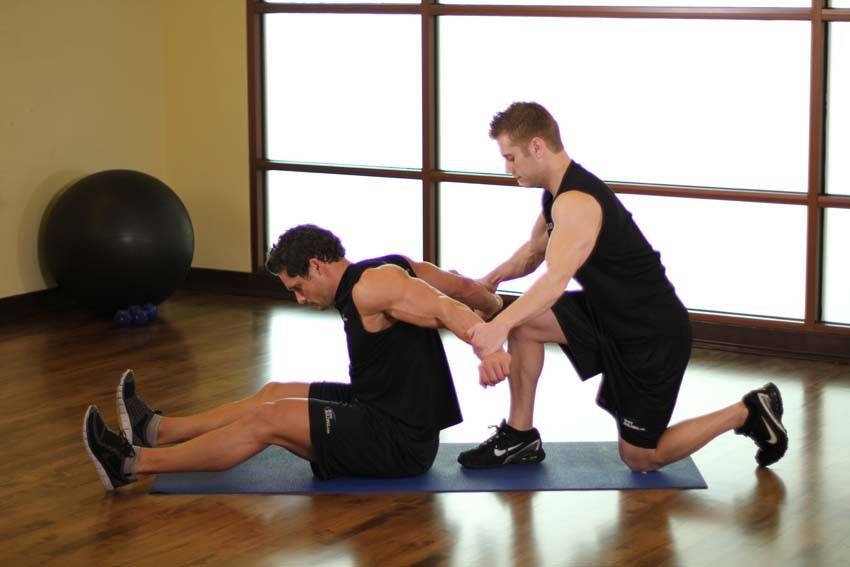 Demonstration of Seated Front Deltoid exercise showing proper form and technique