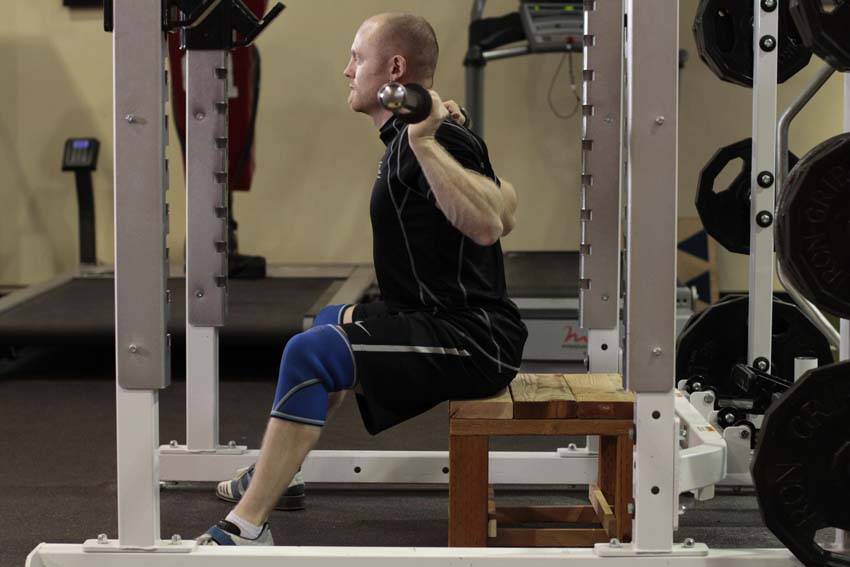 Demonstration of Seated Good Mornings exercise showing proper form and technique