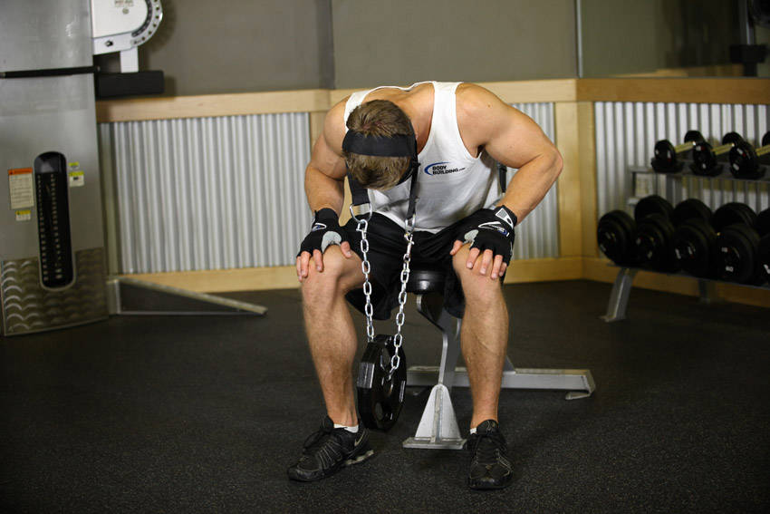 Demonstration of Seated Head Harness Neck Resistance exercise showing proper form and technique