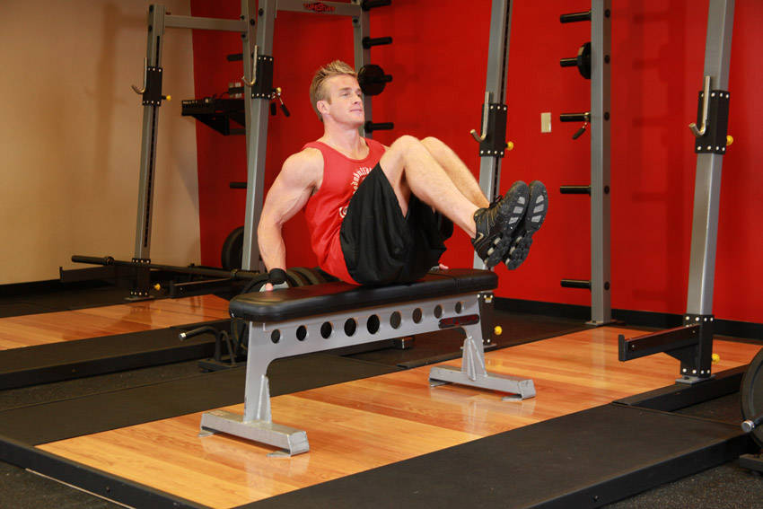 Demonstration of Seated Leg Tucks exercise showing proper form and technique