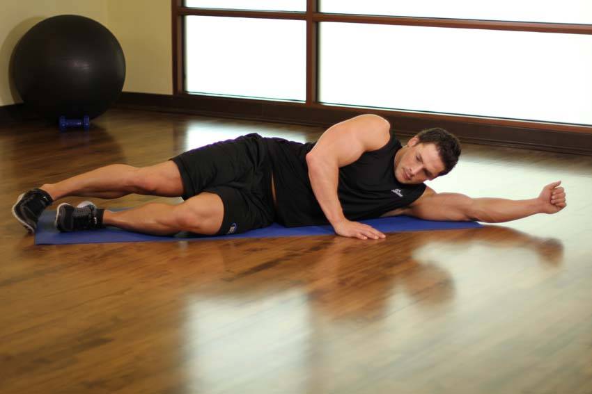 Demonstration of Side-Lying Floor Stretch exercise showing proper form and technique