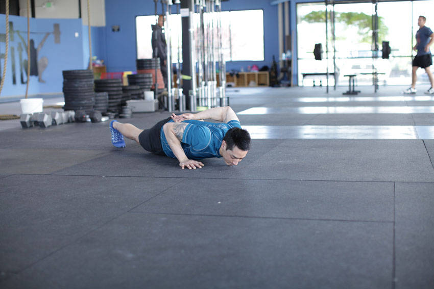Demonstration of Single-Arm Push-Up exercise showing proper form and technique