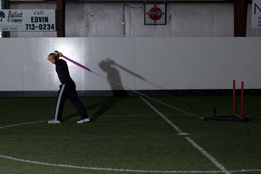 Demonstration of Sled Overhead Triceps Extension exercise showing proper form and technique