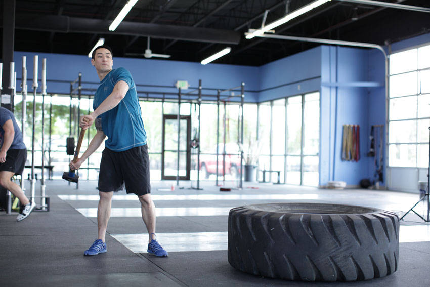 Demonstration of Sledgehammer Swings exercise showing proper form and technique