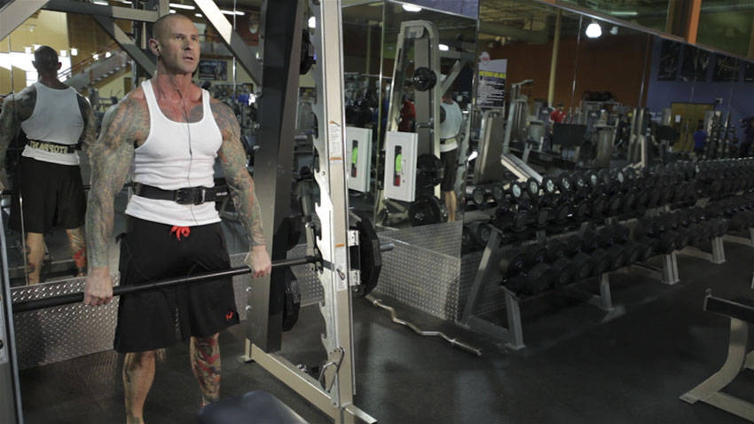 Demonstration of Smith Machine Hang Power Clean exercise showing proper form and technique