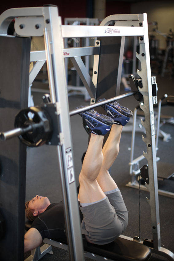 Demonstration of Smith Machine Hip Raise exercise showing proper form and technique