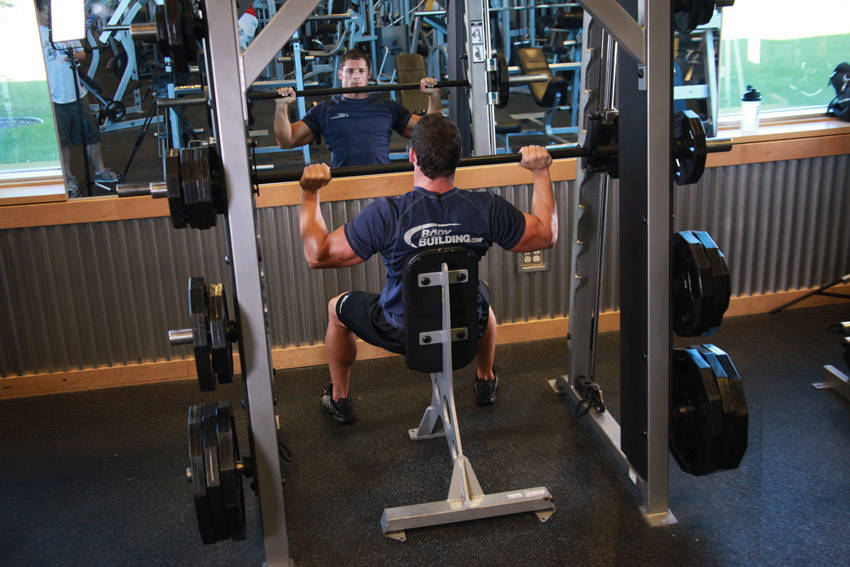 Demonstration of Smith Machine Overhead Shoulder Press exercise showing proper form and technique