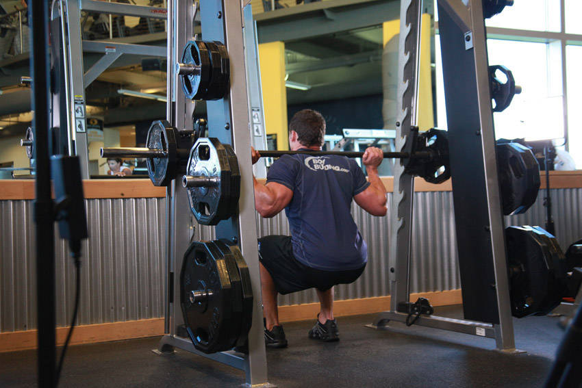 Demonstration of Smith Machine Squat exercise showing proper form and technique