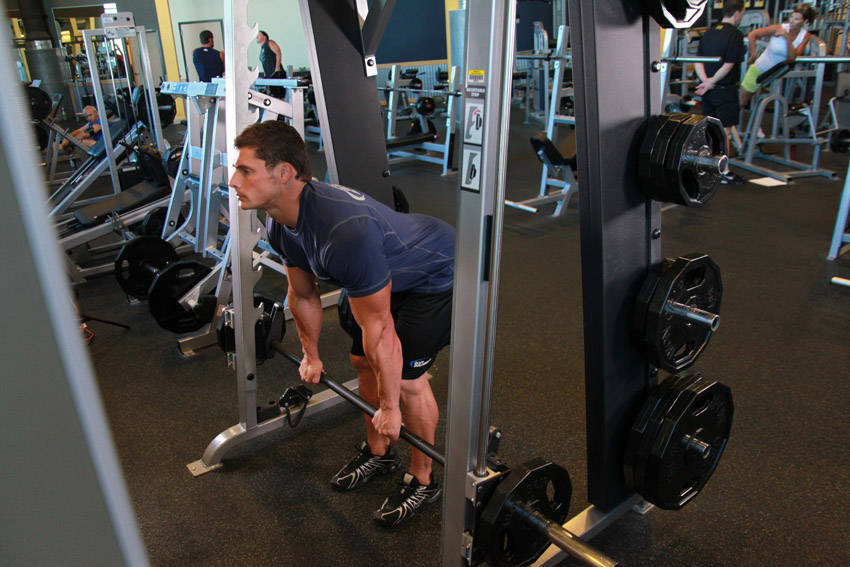 Demonstration of Smith Machine Stiff-Legged Deadlift exercise showing proper form and technique