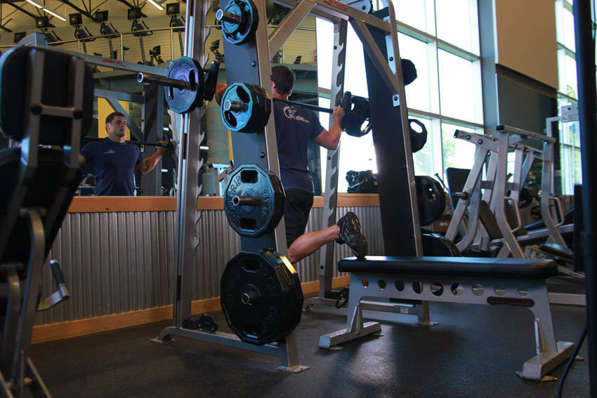Demonstration of Smith Single-Leg Split Squat exercise showing proper form and technique