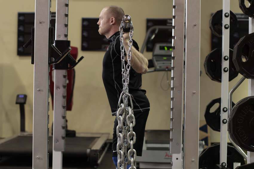 Demonstration of Squat with Chains exercise showing proper form and technique