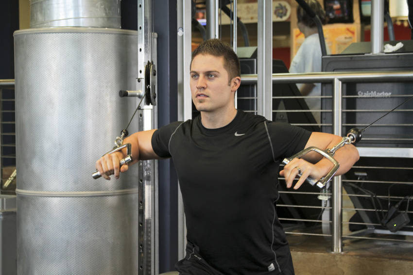 Demonstration of Standing Cable Chest Press exercise showing proper form and technique