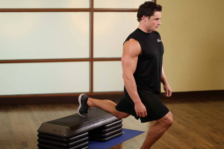 Demonstration of Standing Elevated Quad Stretch exercise showing proper form and technique