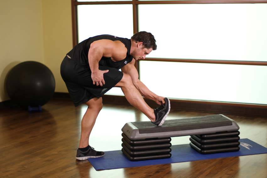 Demonstration of Standing Gastrocnemius Calf Stretch exercise showing proper form and technique
