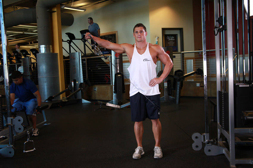 Demonstration of Standing Low-Pulley Deltoid Raise exercise showing proper form and technique